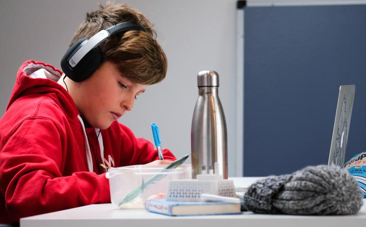 Student with headphones doing homework